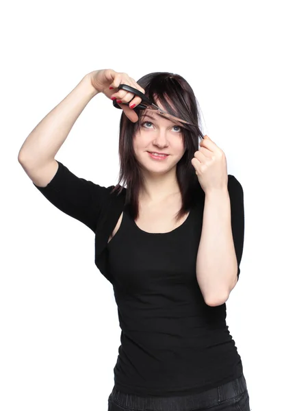 Giovane donna tagliando la frangia su sfondo bianco — Foto Stock