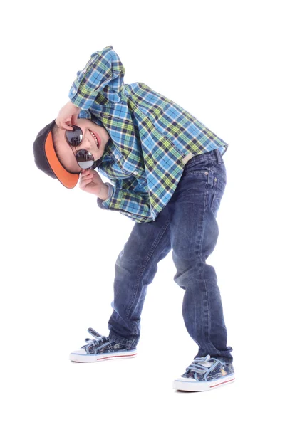 Ganzkörperporträt eines lächelnden kleinen Jungen in Jeans, Tasse und Sonnenbrille auf weißem Hintergrund — Stockfoto