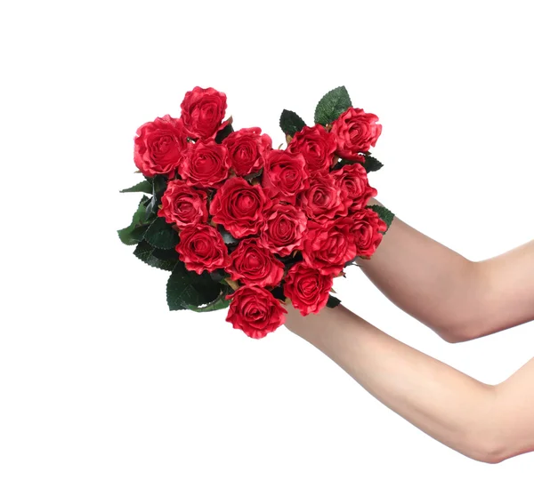 Weibliche Hände, die ein Herz aus roten Rosen halten — Stockfoto