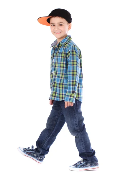 Ganzkörperporträt eines lächelnden kleinen Jungen in Jeans und Tasse auf weißem Hintergrund — Stockfoto