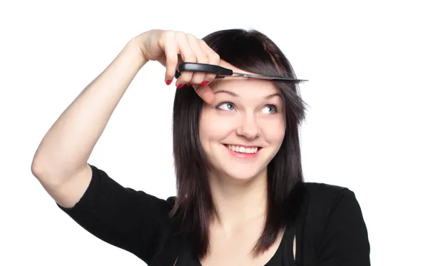 Young woman cutting her fringe over white background — Stock Photo, Image