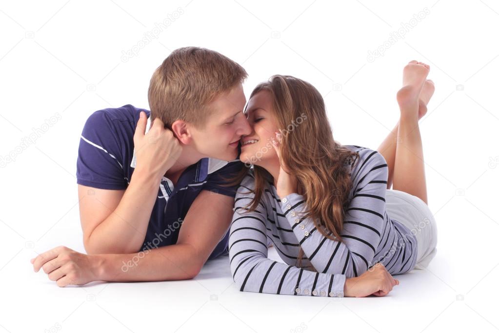 Happy young couple lying down on the floor and kissing