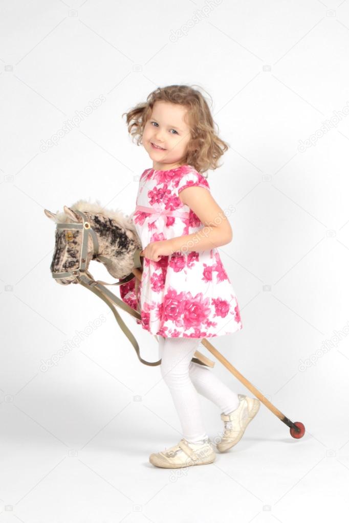 Cute little girl riding a stick horse