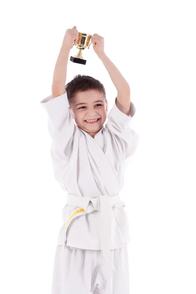 Jovem menino lutador vencedor em quimono branco com copo — Fotografia de Stock