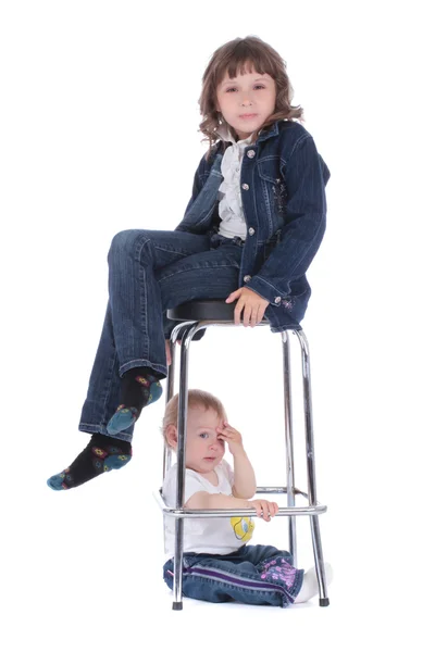 Petite fille sur la chaise et petit bébé sous le studio — Photo