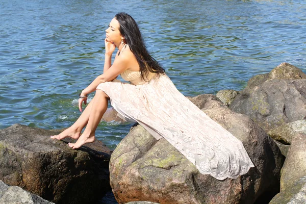 Wanita muda yang duduk di pantai laut — Stok Foto