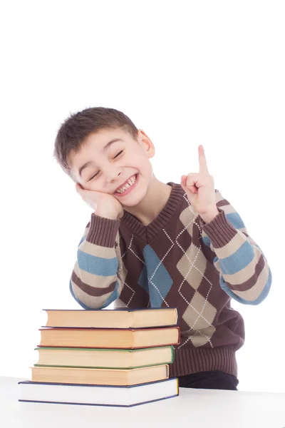 Мальчик с книгами показывает пальцем вверх — стоковое фото