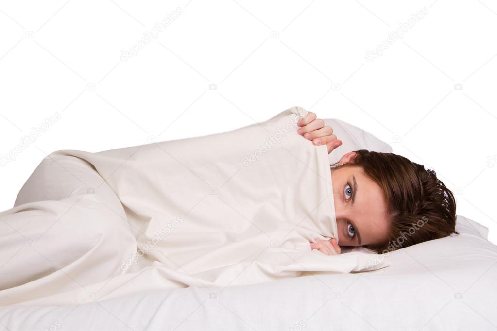 Girl is hiding under the white blanket