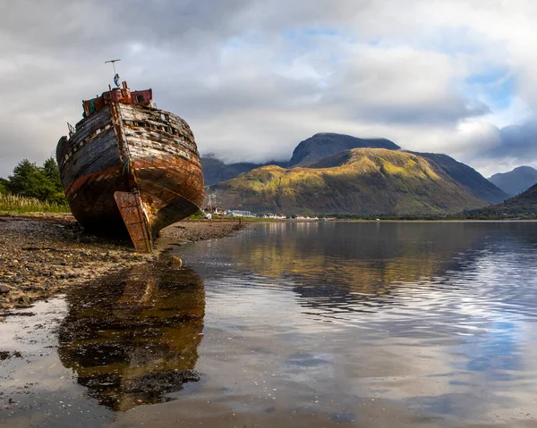 船は遠くにベン ネビスと一緒にクールの古いボートを破壊しました スコットランドのハイランドで — ストック写真