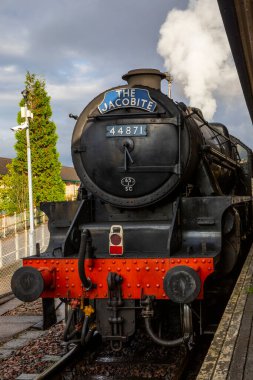 Fort William, İskoçya - 9 Ekim 2021: Bir Jakobit buharlı treni Fort William 'dan İskoçya' nın Highlands bölgesindeki Glenfinnan Viyadük 'ünden geçiyor..