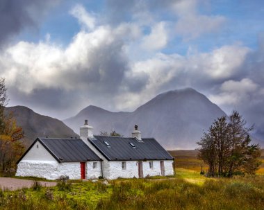 Glencoe, İskoçya - 10 Ekim 2021: Arka planda Buachaille Etive Mor, İskoçya 'daki Glencoe Etive bölgesinde Blackrock Cottage' ın pitoresk manzarası.