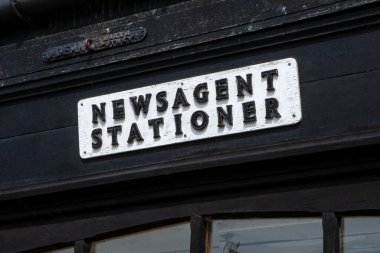 Essex, İngiltere 'deki güzel bir kasaba olan Thaxted' de bir mağazanın dış tarafında antika bir gazete bayii ve kırtasiyeci tabelası..