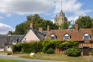 Suffolk, İngiltere - 11 Ağustos 2021: Bakire Meryem Kilisesi ve Suffolk, İngiltere 'deki Cavendish köyündeki kır evlerinin manzarası. 