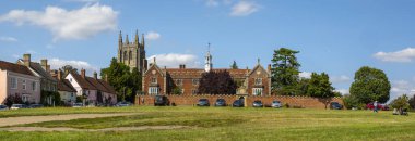 Suffolk, İngiltere - 11 Ağustos 2021: Suffolk, İngiltere 'deki güzel Long Melford köyünün panoramik manzarası. Görüntüler arasında Kutsal Üçleme Kilisesi ve Trinity Hastanesi binası da yer alıyor..