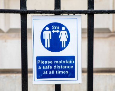 Londra 'nın merkezinde, COVID-19 salgını sırasında halka güvenli bir mesafede durmaları gerektiğini hatırlatan bir sosyal uzaklık tabelasına yakın çekim..