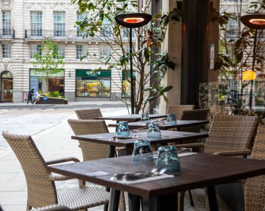 Londra, İngiltere - 13 Mayıs 2021: Londra 'nın merkezindeki bir restoranın dışındaki boş masalar.