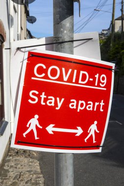 İngiltere 'nin Cornwall kentindeki Mevagissey balıkçı köyünde COVID-19 sosyal mesafe işareti..