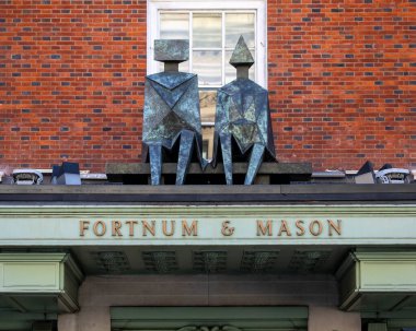 Londra, İngiltere - 8 Mart 2022: Londra, İngiltere 'de Piccadilly' de bulunan ünlü Fortnum ve Mason mağazasının girişinde bir heykel ve tabela.