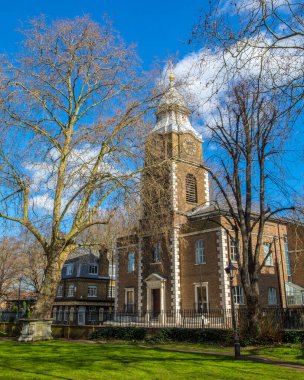 London, UK - March 17th 2022: Across the former churchyard of St. Johns church in Wapping, London. The church tower of the former St. Johns Church is seen across the square.