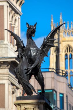 Londra 'daki Fleet Caddesi' ndeki Temple Bar Dragon heykeli. Ejderha, Westminster şehrinin Londra şehriyle buluştuğu sınır tabelasıdır. Arka planda St. Dunstan-in-the-West kulesi var..