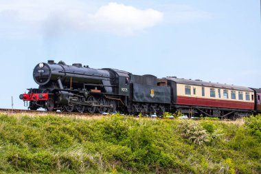 Sheringham, İngiltere - 16 Mayıs 2022: Kuzey Norfolk Demiryolu hattında çalışan bir buhar treni, Poppy Line olarak da bilinir, Norfolk, İngiltere 'deki Sheringham kasabası yakınlarında resmedildi..