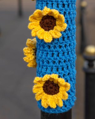 Birleşik Krallık 'ın Oxfordshire kentindeki tarihi pazar kasabası Chipping Norton' da Ukrayna 'yı desteklemek için örülmüş bir parçanın yakın çekimi..