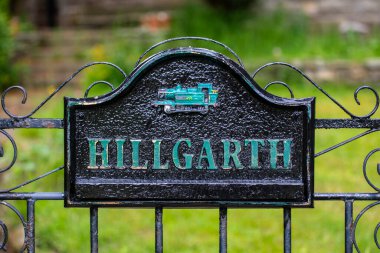Goathland, İngiltere - 9 Haziran 2022: Kuzey York Moors, İngiltere 'deki Goathland köyündeki bir kulübeye açılan bir geçitte buharlı bir lokomotifi resmeden bir plaketin yakın çekimi.