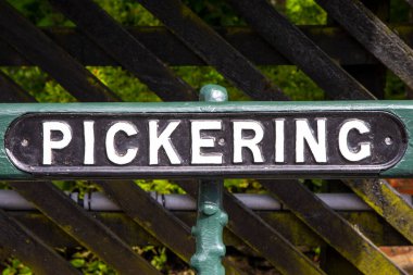 Kuzey Yorkshire, İngiltere 'deki güzel Pickering kasabasında bir bankta Pickering tabelası..