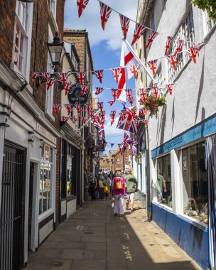 Whitby, İngiltere - 10 Haziran 2022: Kuzey Yorkshire, İngiltere 'deki Whitby sahil kasabasında Sandgate' in görüntüsü. Queens Platin Yıl dönümü anısına sendika bayrağı asılıyor..