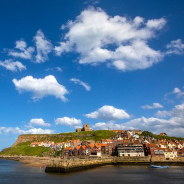 Kuzey Yorkshire, İngiltere 'nin güzel sahil kasabası Whitby' deki Doğu Kayalıkları manzarası. St. Mary Kilisesi uçurumun tepesine tünemiştir..