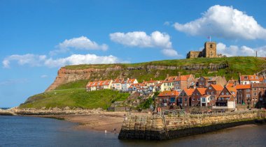 St. Marys Kilisesi 'nin panoramik manzarası İngiltere' nin Kuzey Yorkshire kentindeki Whitby sahil kasabasındaki Doğu Kayalıkları 'na tünemişti..