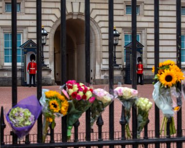 Londra, İngiltere - 9 Eylül 2022: Bir önceki gün ölen Kraliçe II. Elizabeth 'in anısına Londra' daki Buckingham Sarayı 'nda kraliyet muhafızları ve çiçekler.