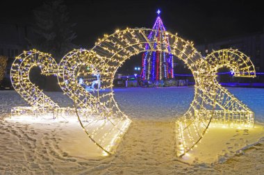 Ukrayna 'nın İvano-Frankivsk bölgesindeki Tysmenytsia' da Noel ve Yeni Yıl tesisi. 24 Aralık 2021. Editör fotoğrafı. Yüksek ISO değerlerine sahip kötü ışıklandırma koşullarında akşam çekimleri