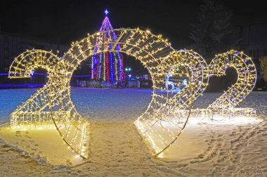 Ukrayna 'nın İvano-Frankivsk bölgesindeki Tysmenytsia' da Noel ve Yeni Yıl tesisi. 24 Aralık 2021. Editör fotoğrafı. Yüksek ISO değerlerine sahip kötü ışıklandırma koşullarında akşam çekimleri
