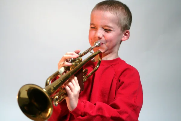 Expressif garçon frapper un trompette haute note — Photo