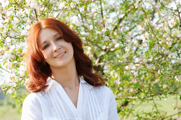 Girl on the background of a flowering tree — Stock Photo, Image