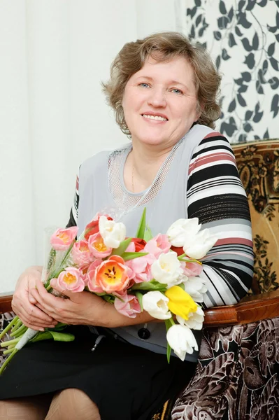 An elderly woman with a bouquet of flowers — Stock Photo, Image