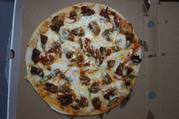 Pizza with beef meat in cardboard box