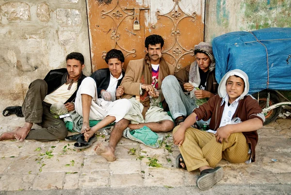 男人和男孩咀嚼街头咖特阿拉伯茶萨那市也门 免版税图库图片