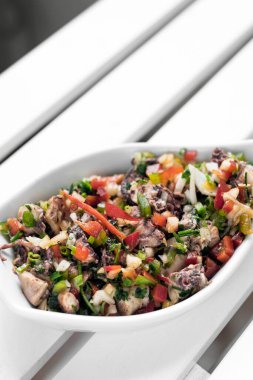 Atina 'daki beyaz restoran masasında geleneksel Yunan ahtapot salatası kasesi