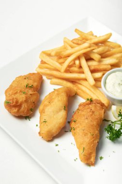 İngiliz geleneksel balık ve patates kızartması beyaz tabakta yenir.