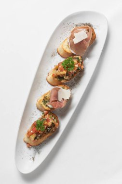 Jamon serrano jambonlu Bask Pinchos tapas ve Bilbao İspanya 'nın beyaz arka planında domates bruschetta.