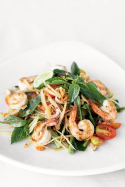 Thai geleneksel som tam baharatlı papaya salatası beyaz arka planda karidesli.
