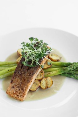 Kuşkonmaz, patates ve tereyağı soslu ızgara somon.