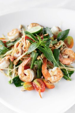 Thai geleneksel som tam baharatlı papaya salatası beyaz arka planda karidesli.