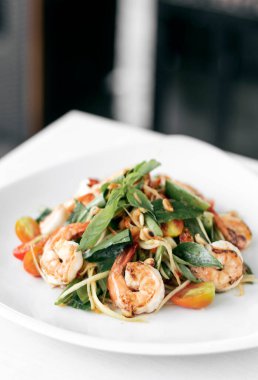 thai traditional spicy papaya salad with fresh prawns and basil