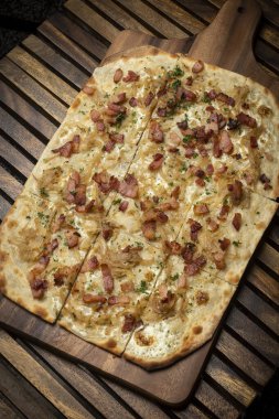 Flammkuchen tarte flambee rectangular pizza with bacon and chicken on wood table background