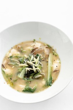 Japon miso çorbası tofu, shiitake mantarı, bok choy ve deniz yosunu beyaz arka planda.