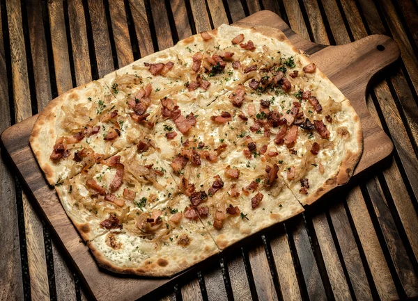 Flammkuchen tarte flambee rectangular pizza with bacon and chicken on wood table background