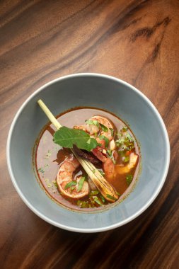 thai tom yam kung spicy curry soup with prawns on wood table